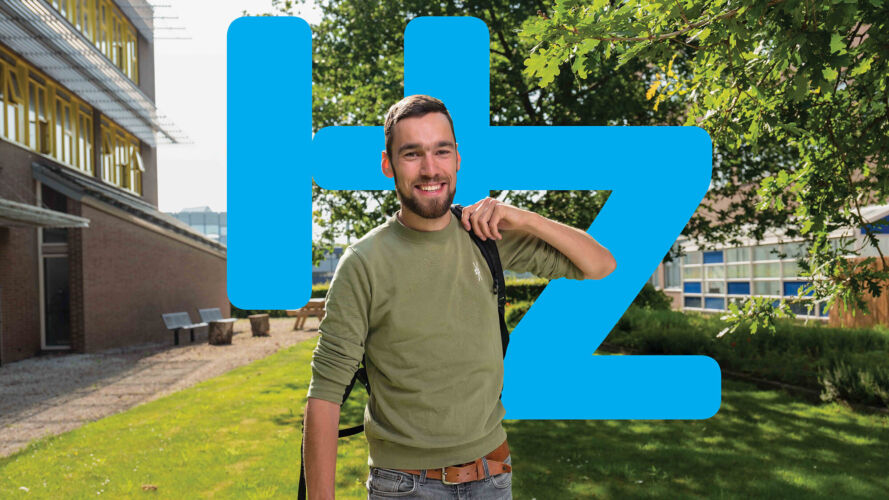 Portret van Social Work student buiten bij de HZ in Vlissingen. Achter zijn lichaam zie je "HZ" in grote blauwe letters.