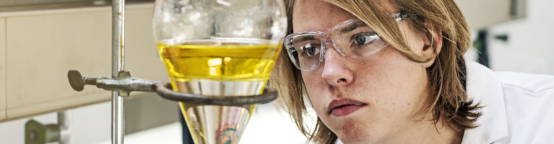 Chemie student met een veiligheidsbril op