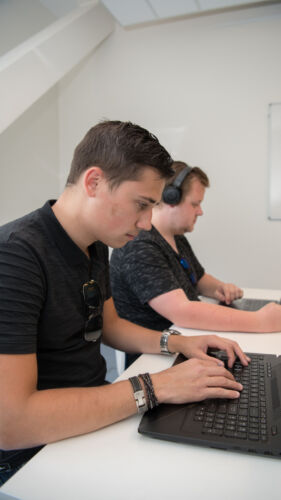 HBO-ICT studenten die werken aan een project op hun laptop