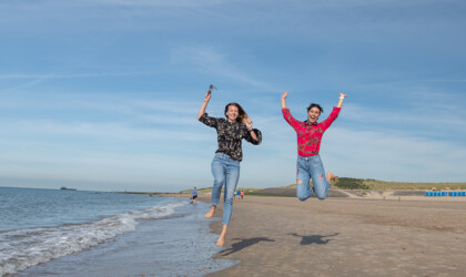 Two international students jump up on the beach