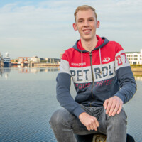 Foto van Lars, student Watermanagement, met in de achtergrond de haven van Vlissingen