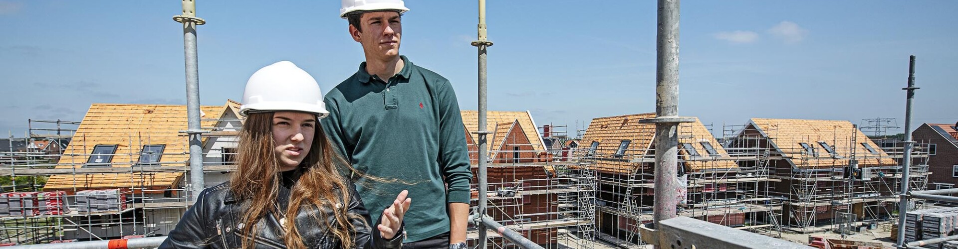 Twee Bouwkunde studenten op een bouwplaats met helm op