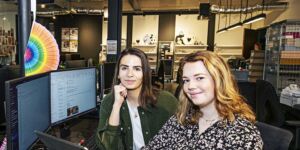 Twee Communicatie studenten zitten samen aan een bureau