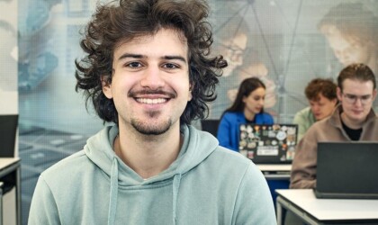 ICT student sitting in a classroom with other students in the background