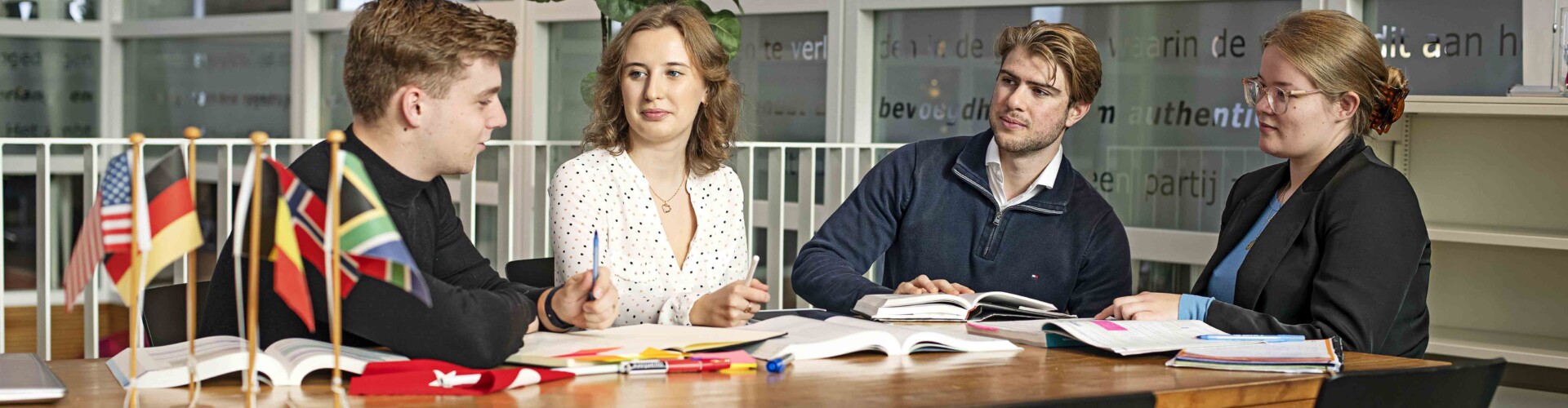 Groepje International Business studenten werken samen aan een tafel
