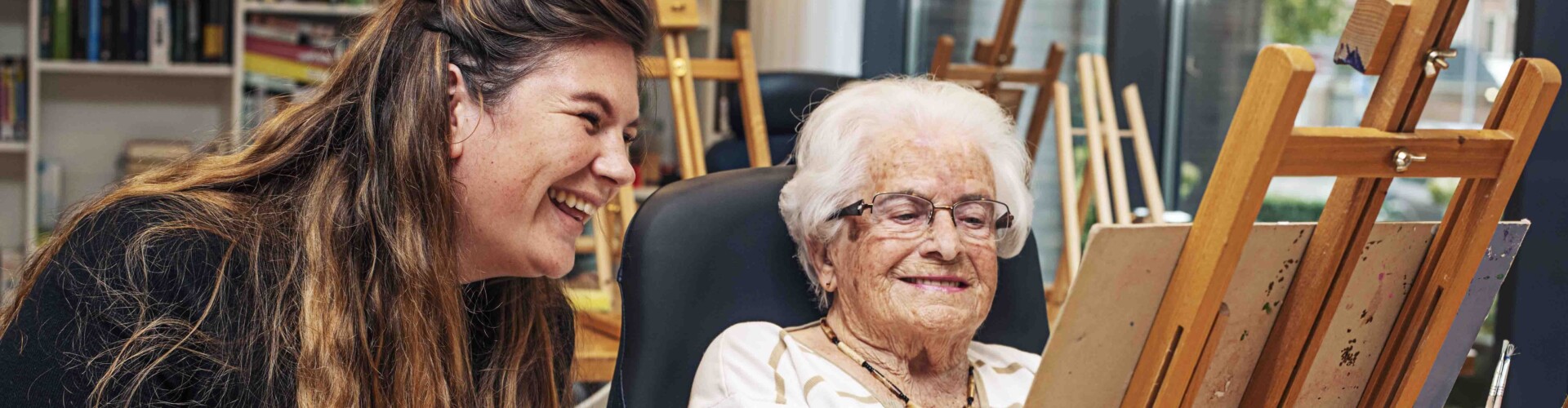 Social Work student die samen met een oudere vrouw aan het schilderen is