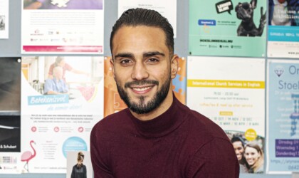 Portret van mannelijke Social Work studenten voor een muur met posters