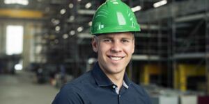 Portret van Technische Bedrijfskunde student met een veiligheidshelm op in een scheepswerf