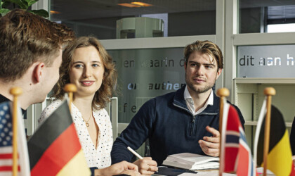 International students sitting at a table with multiple small flags on it