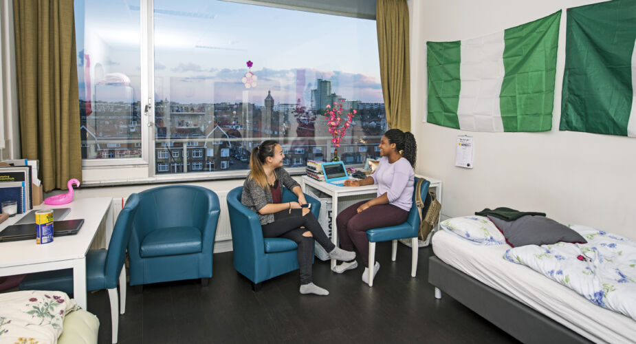Students sitting together at a table in their student room with Vlissingen in the background