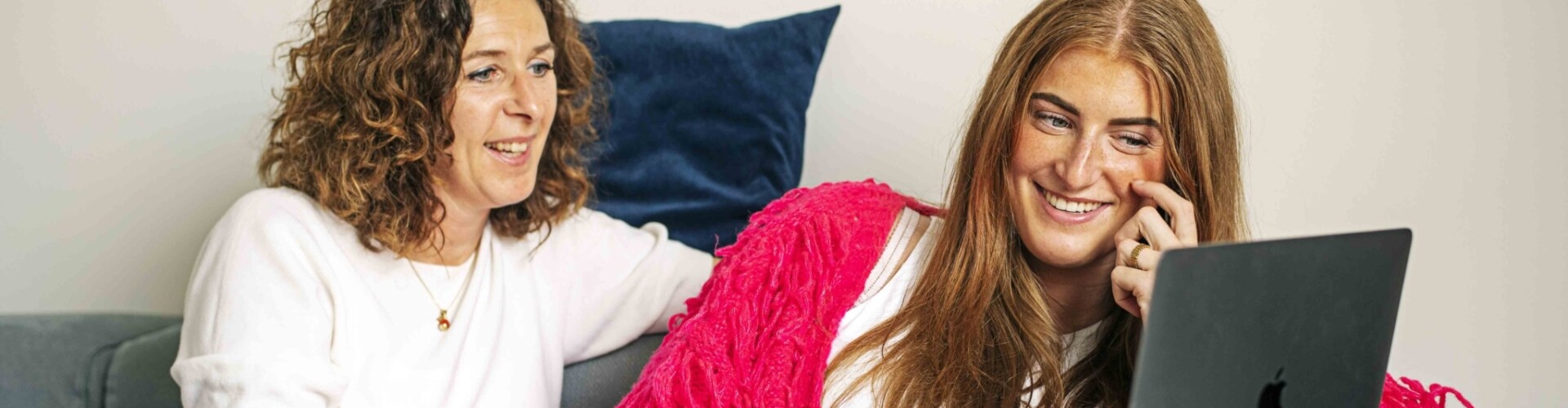 Student kijkt op laptop samen met haar moeder
