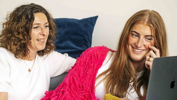 Student kijkt op laptop samen met haar moeder