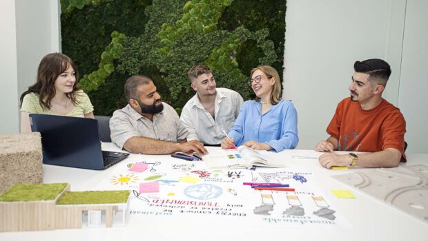 Studenten werken samen aan een project en krijgen hulp van een docent