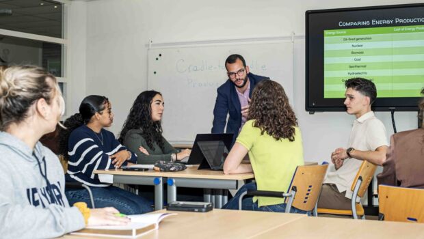 Studenten in een klaslokaal met een docent die uitleg geeft