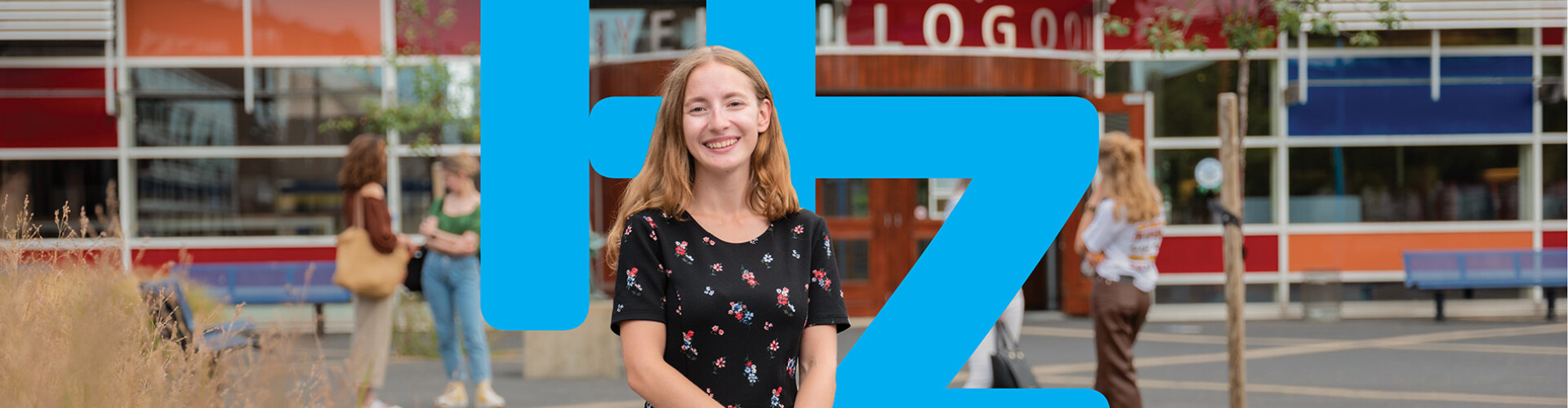 Student in front of HZ building with logo HZ