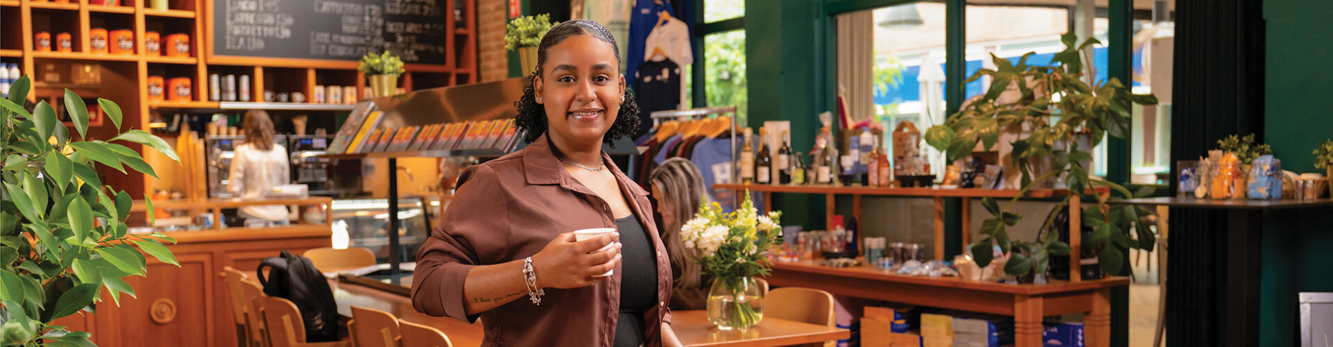 HZ student in de HZ Shop met een koffiebeker in haar hand