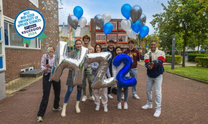 Students celebrating the second place in the Keuzegids with balloons and confetti