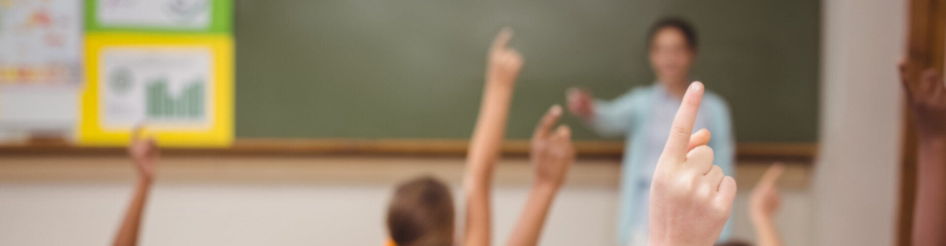 Kids holding up their hand in class