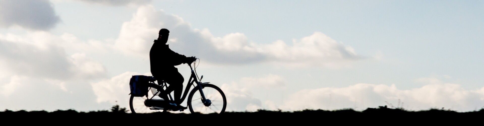 Een persoon die over een dijk fietst