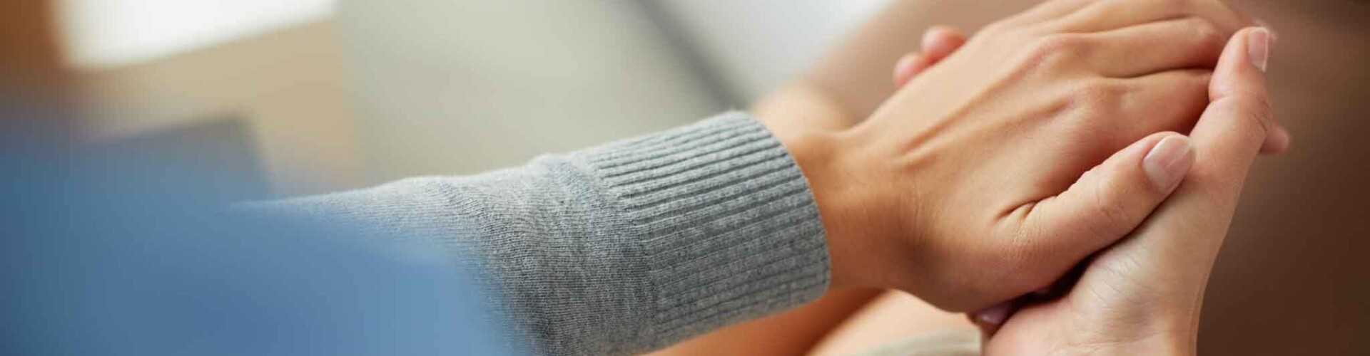 Twee handen die de hand van iemand anders vasthouden