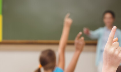 Kinderen die hun vinger opsteken in de les