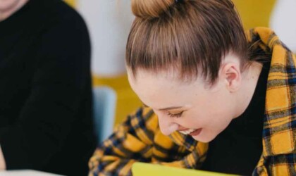 Student die lacht met een andere student naast haar