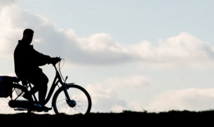 Een persoon die over een dijk fietst