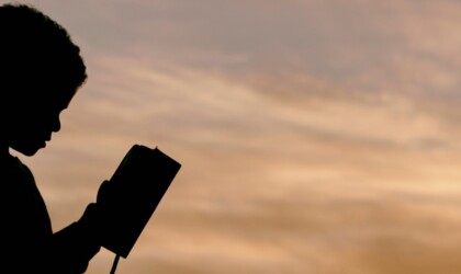 Jongen leest een boek in de schemering