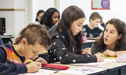 Docent helpt scholier met leren lezen