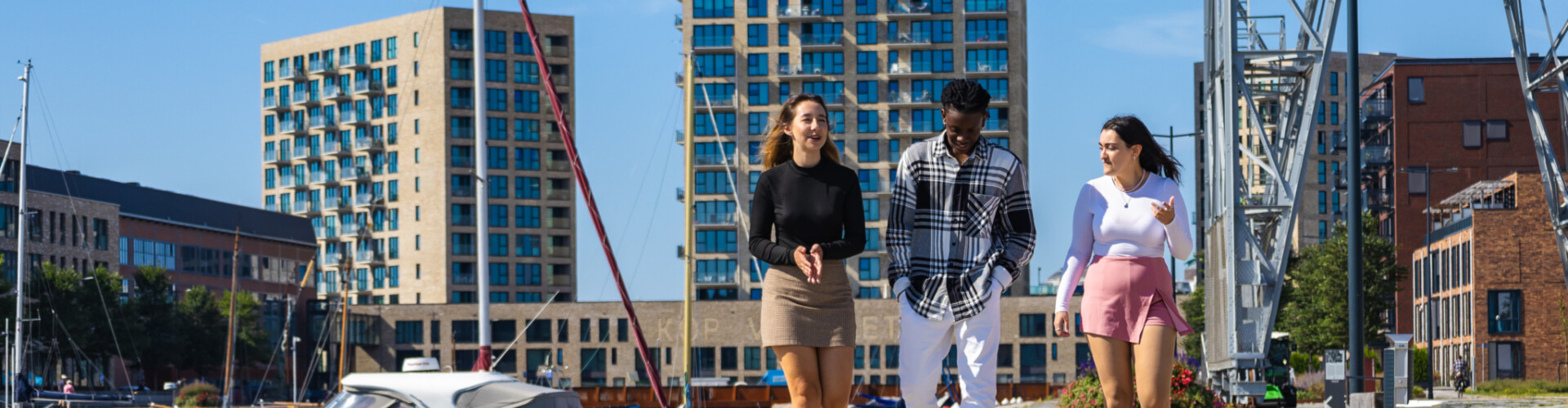 Three international students walking and talking by the harbour in Vlissingen