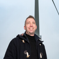 HZ-student Ben staat bij een windmolen