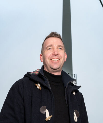 HZ-student Ben staat bij een windmolen