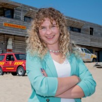 Engineering alumnus voor het gebouw van de strandwacht