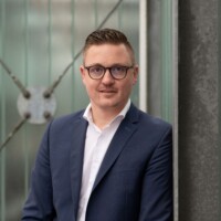Paul Grinwis posing and leaning against the side of a building