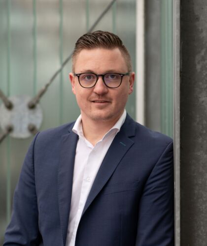 Paul Grinwis posing and leaning against the side of a building