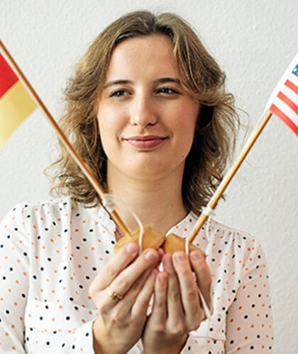 Erika is holding little flags of Germany and the United States of America