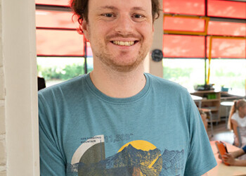 Student Leraar Basisonderwijs Nando poseert voor de deur van de schoolklas