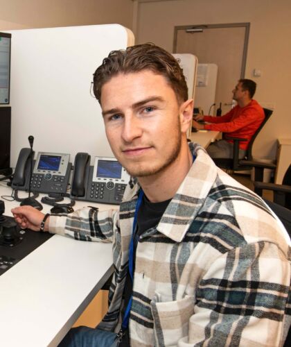 Foto van Zino, student Logistics Engineering, achter een bureau