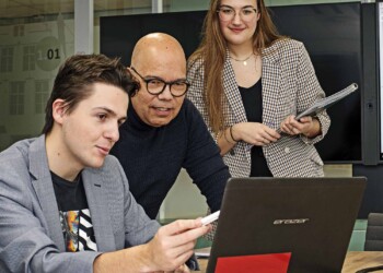 Twee Finance & Control studenten kijken naar laptop met werkgever