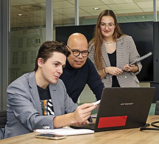 Finance & Control studenten kijken samen met opdrachtgever naar een laptop