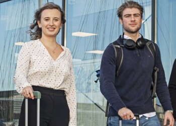 Twee International Business studenten met hun rolkoffers bij een vliegveld