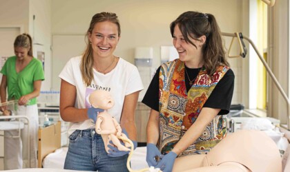 Twee HZ Verpleegkunde & Vroedkunde studenten zijn bezig met een nep bevalling