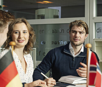 International students sitting at a table with multiple small flags on it