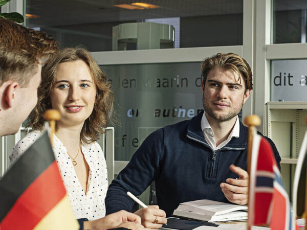 Internationale studenten studeren samen aan tafel met vlaggetjes