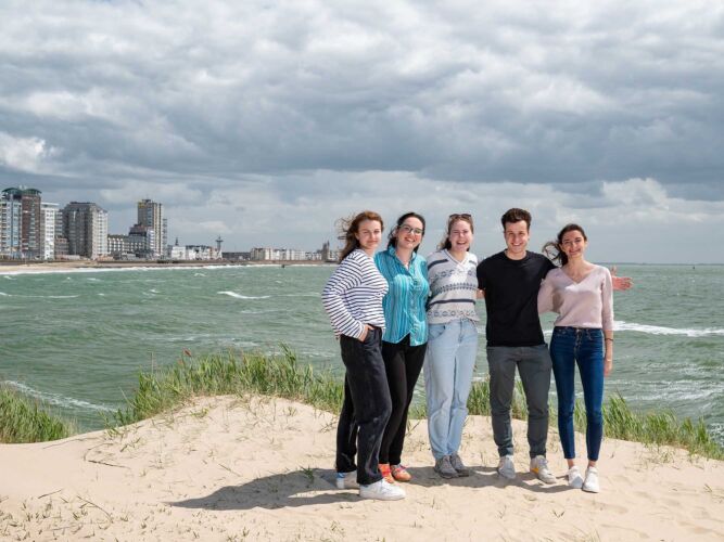 Group of students on the beach of Vlissingen with the skyline in the background