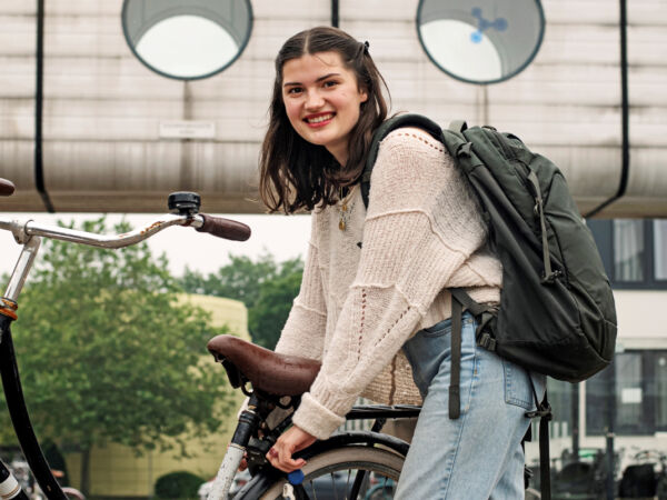 Internationale student die haar fiets van het slot haalt