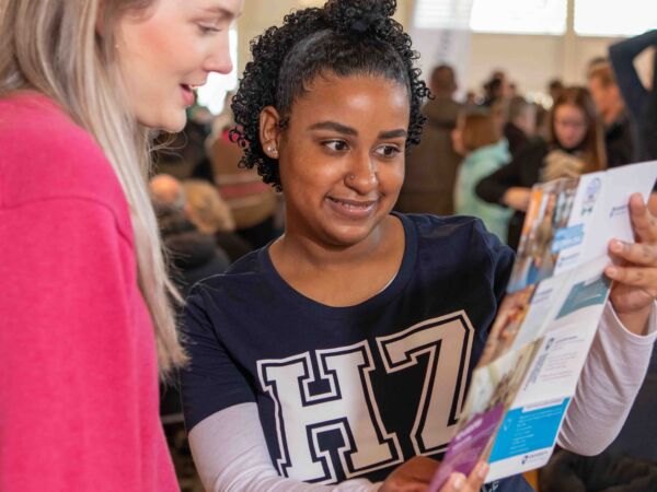 HZ student die een studiekiezer de weg wijst tijdens een open dag