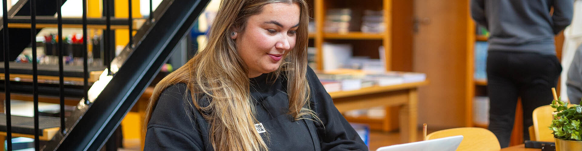 Student achter haar laptop in de HZ Shop