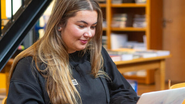 Student achter haar laptop in de HZ Shop