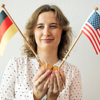 Erika is holding little flags of Germany and the United States of America